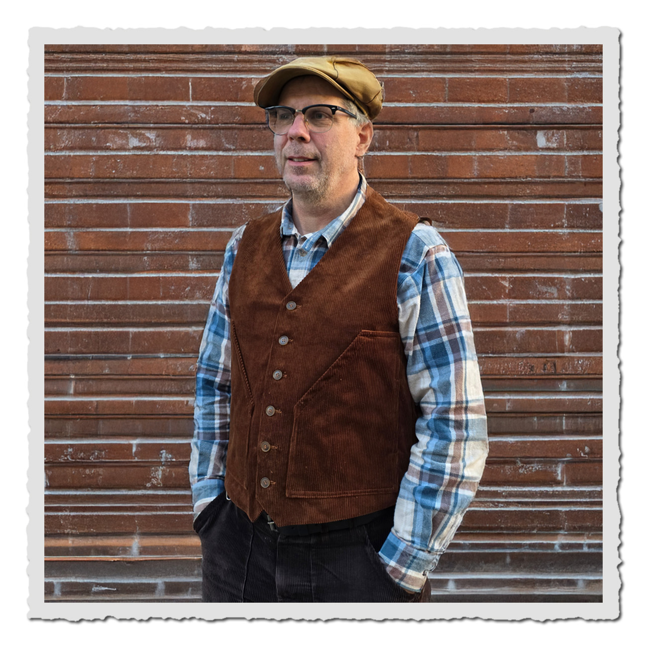 Mann vor Steinmauer trägt die Retronia Cord Weste Erwin – Weste mit Knopfleiste und Taschen